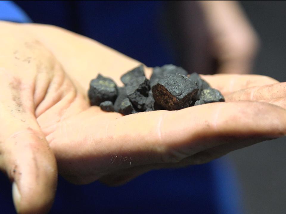 A Metals Company employee holding a handful of nodules