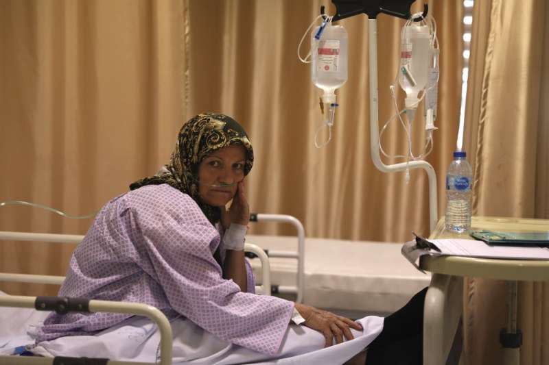 伊朗的新冠疫情嚴重，首都德黑蘭醫院裡的一名新冠肺炎病患正坐在床上（美聯社）