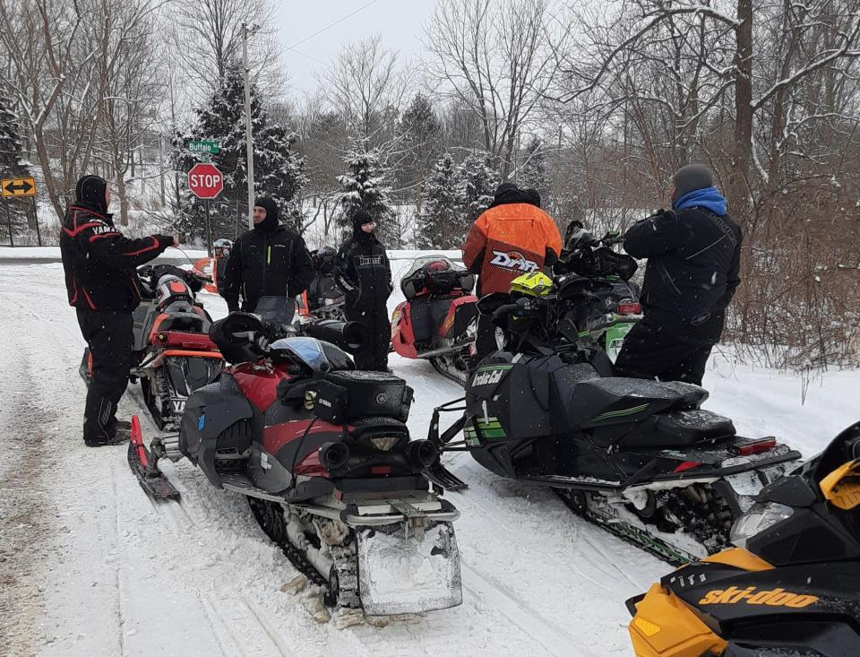 Members of the Snowbusters Snowmobile Club stop during a club ride along Trail 182 at Buffalo and Adams roads near Galien.