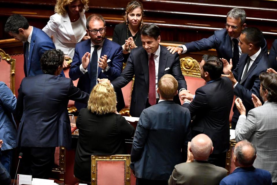 Italian Premier Giuseppe Conte, center, is congratulated at the end of his address to the Senate, in Rome, Tuesday, Aug. 20, 2019. Italian Premier Giuseppe Conte has told senators he’s handing in his resignation because his right-wing coalition partner has yanked its support for the populist government. (Ettore Ferrari/ANSA via AP)