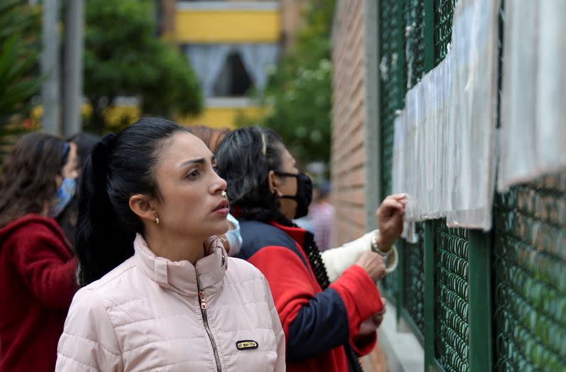Una mujer verifica su mesa de votación en un centro electoral de Bogotá
