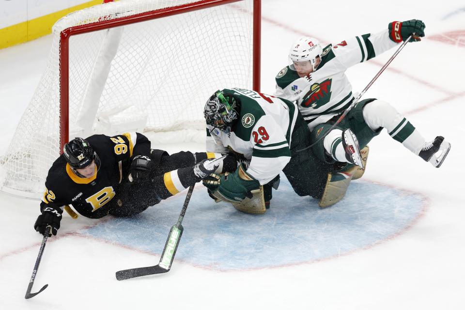 Boston Bruins' Tomas Nosek (92) and Minnesota Wild's Calen Addison (2) collide with Wild goalie Marc-Andre Fleury (29) during the second period of an NHL hockey game, Saturday, Oct. 22, 2022, in Boston. (AP Photo/Michael Dwyer)