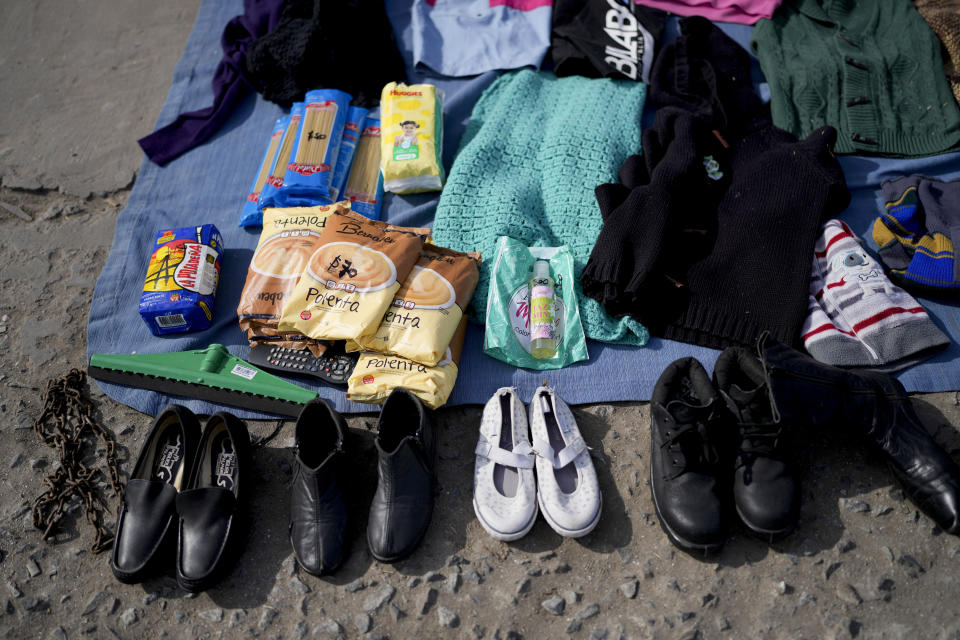 Prendas de segunda mano y algunos productos alimenticios se exhiben en un mercado donde la gente puede comprar o intercambiar bienes en las afueras de Buenos Aires, Argentina, el miércoles 10 de agosto de 2022.( AP Foto/Natacha Pisarenko)