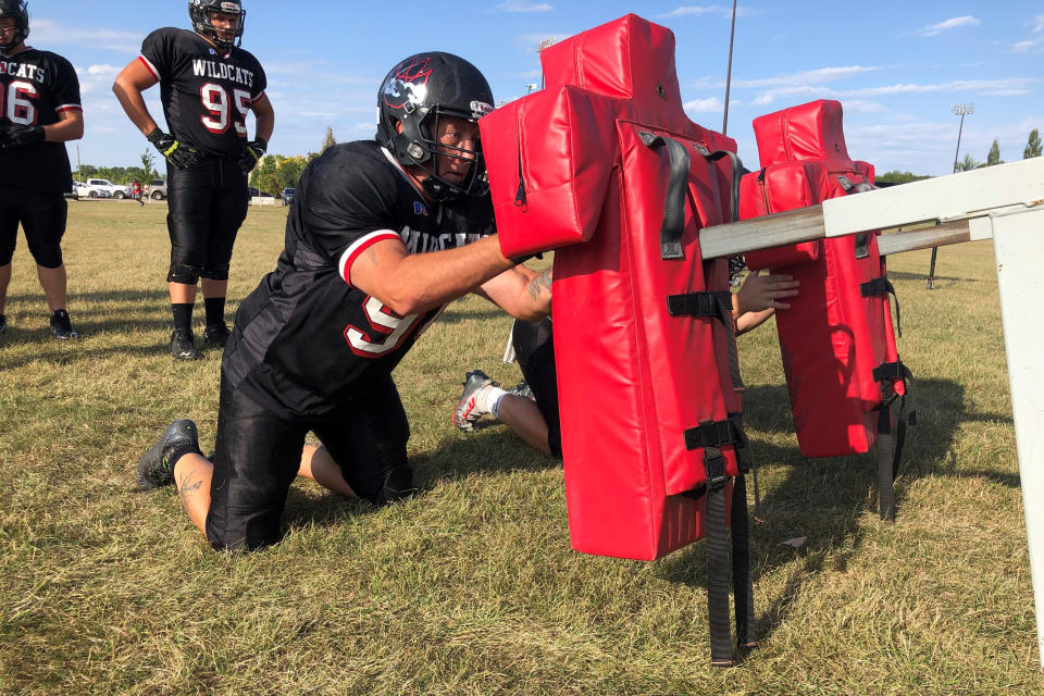 Ray Ruschel, a 49-year-old freshman football player for the North Dakota State College of Science, takes his turn on the blocking sled on Tuesday, Sept. 20, 2022, in Wahpeton, N.D. Ruschel had not played football since he was in high school in Pennsylvania. He plays defensive line for the Wildcats, mostly at nose guard. “He holds his own,” teammate Manny Garcia says. (AP Photo/Dave Kolpack)