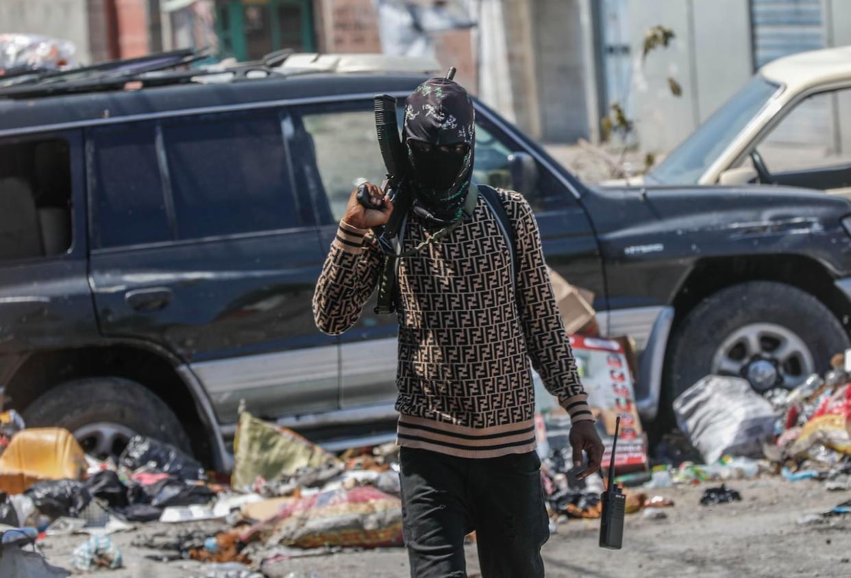 An armed member of the G9 and Family gang patrols a roadblock in the Delmas 6 neighborhood of Port-au-Prince, Haiti on March 11, 2024. (Odelyn Joseph/The Associated Press - image credit)