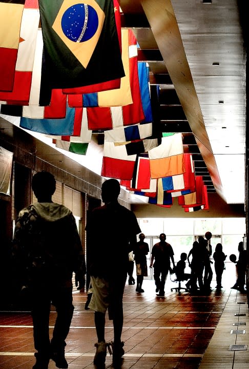 Brad Nading/Telegram Garden City High School freshmen make their way through the main hallway in August under flags representing each country of origin for students at the school. (Courtesy: Finney County Historical Society)