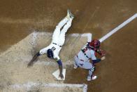 Milwaukee Brewers' Lorenzo Cain scores past St. Louis Cardinals catcher Yadier Molina during the sixth inning of a baseball game Wednesday, May 12, 2021, in Milwaukee. Cain scored from second on a ball hit by Travis Shaw. (AP Photo/Morry Gash)