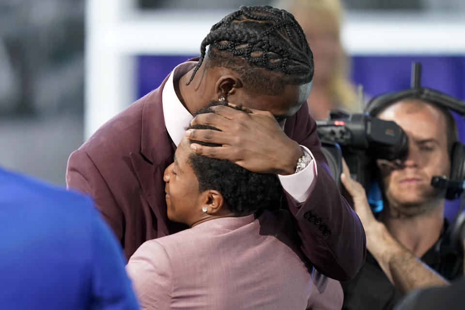 Jalen Duren hugs family members after being selected 13th overall by the Charlotte Hornets in the NBA basketball draft, Thursday, June 23, 2022, in New York. (AP Photo/John Minchillo)