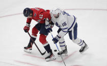 Washington Capitals' Martin Fehervary (42) and Alexander Kerfoot (15) compete for the puck during the second period of an NHL hockey game Monday, Feb. 28, 2022, in Washington. (AP Photo/Luis M. Alvarez)