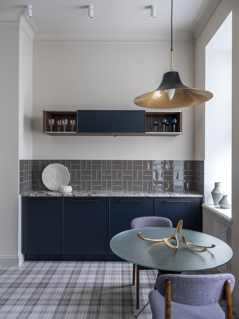 A kitchen with dark toned cabinets and multicolored tiles