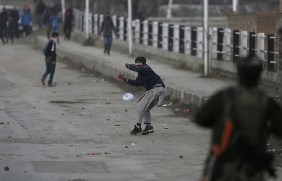 A kashmiri protester throw stones at Indian paramilitary soldiers during a clash in Srinagar, Indian controlled Kashmir, Saturday, Dec. 15, 2018. At least seven civilians were killed and nearly two dozens injured when government forces fired at anti-India protesters in disputed Kashmir following a gunbattle that left three rebels and a soldier dead on Saturday, police and residents said. (AP Photo/Mukhtar Khan)