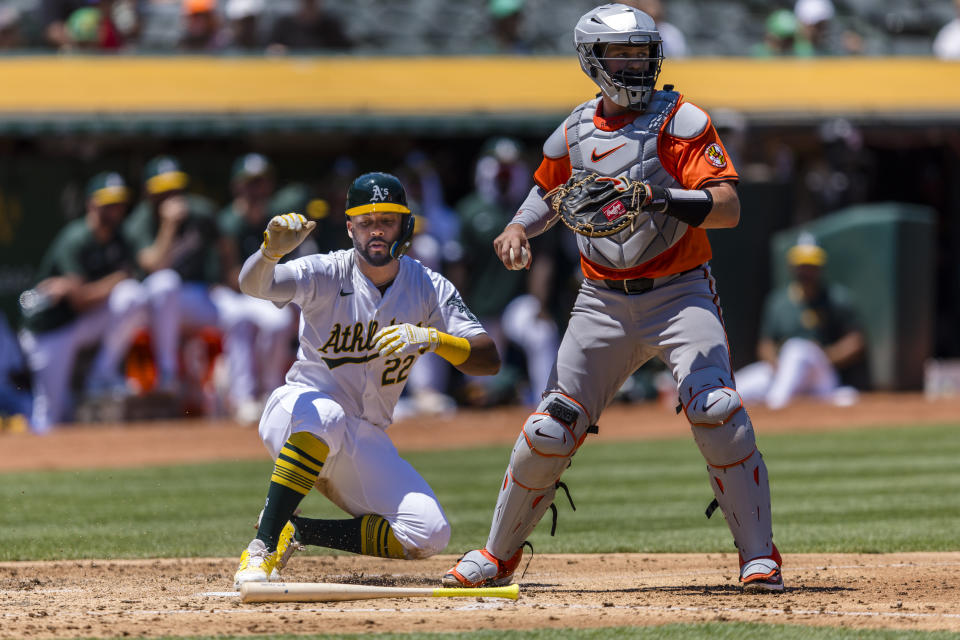 Oakland Athletics' Miguel Andujar (22) scores behind Baltimore Orioles catcher Adley Rutschman during the second inning of a baseball game Saturday, July 6, 2024, in Oakland, Calif. (AP Photo/John Hefti)