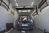 A welder converts a van into a food truck, at a workshop in the West Bank city of Ramallah, Tuesday, Sept. 22, 2020. With dine-in restaurants mostly closed due to health restrictions, food trucks have allowed entrepreneurial Palestinian businessmen to find a way to keep working. (AP Photo/Nasser Nasser)