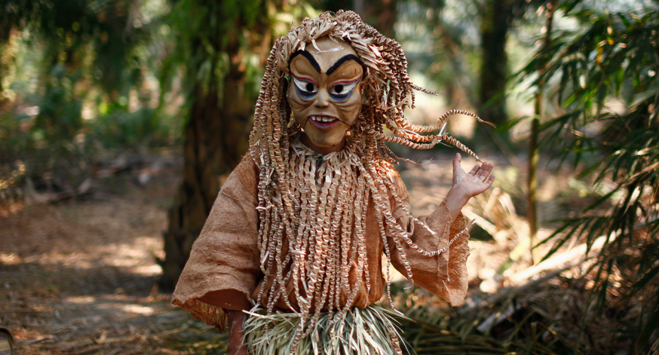 An indigenous man of Malaysia's Mah Meri tribe waits to perform for Ari Muyang festival in the Mah Meri village of Sungai Bumbun at Pulau Carey