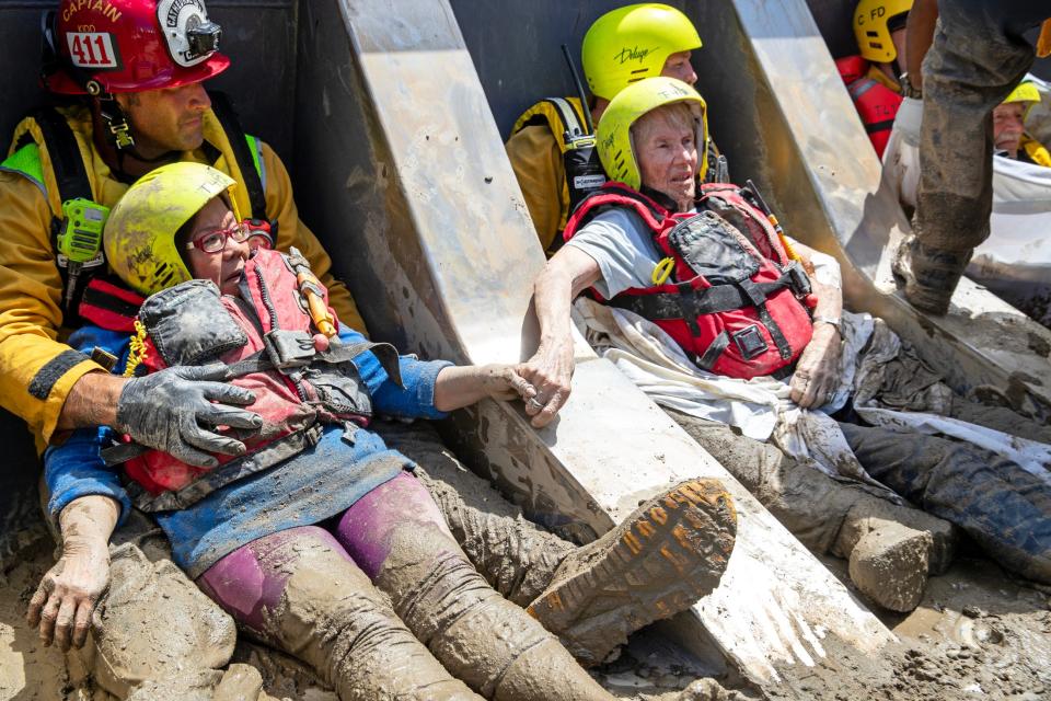 Cathedral City Fire firefighters rescue residents of an elderly care home after the home and roads were inundated with mud from Tropical Storm Hilary in Cathedral City, Calif., on Monday, August 21, 2023.