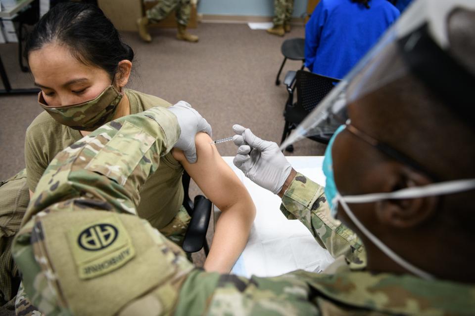 Sgt. Jean Chardins Jeanbapiste gives 1st Lt. Erva Santoso the Pfizer-BioNTech COVID-19 vaccine at Womack Army Medical Center on December 2020. Congress repealed the Department of Defense's vaccine mandate in December.