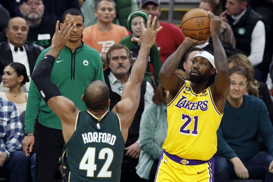 Los Angeles Lakers' Patrick Beverley (21) shoots against Boston Celtics' Al Horford (42) during the first half of an NBA basketball game, Saturday, Jan. 28, 2023, in Boston. (AP Photo/Michael Dwyer)