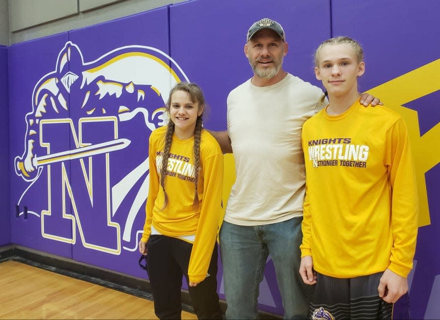 North Henderson High wrestlers Dylan Short, right, and his sister, Gracie, left, pose with their uncle, James Short, prior to their match in December 2021.