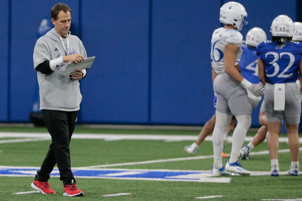 Kansas quarterback coach Jim Zebrowski reviews notes during a spring ball practice this year at the team's indoor facility.