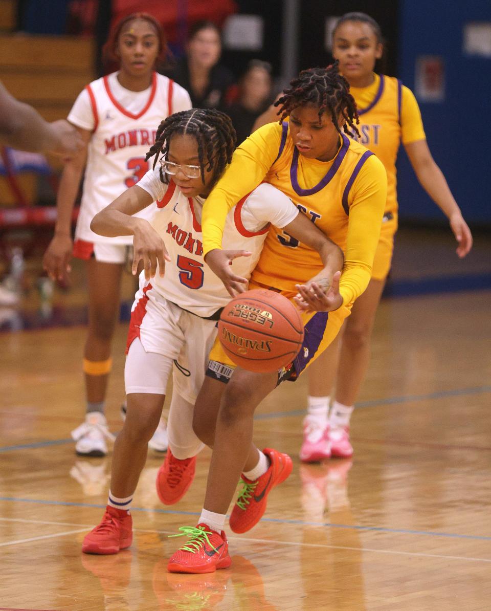 East’s Gabby Brown-Sturdivant reaches over Monroe’s Kamyra Clyburn for a loose ball.