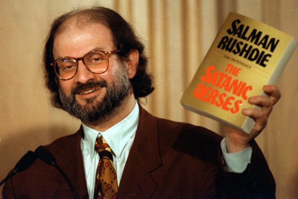 Author Salman Rushdie holds up a copy of his controversial book, "The Satanic Verses" during a 1992 news conference in Arlington, Va.