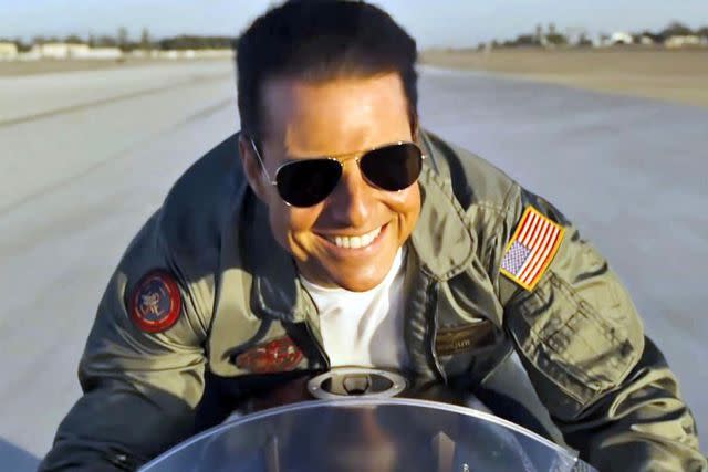 <p>Paramount Pictures/Alamy</p> Tom Cruise riding a motorcycle in 'Top Gun: Maverick.'
