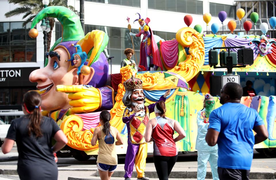Participants run by a Mardi Gras float during the 2020 Rock 'n' Roll New Orleans Marathon in New Orleans.