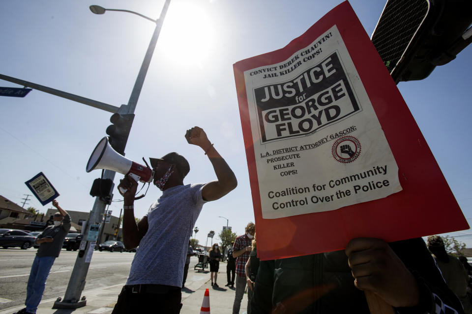 FILE — In this April 20, 2021, file photo, people take part in a rally in Los Angeles after a guilty verdict was announced at the trial of former Minneapolis police Officer Derek Chauvin for the 2020 death of George Floyd. Under a new law that went into effect July 1, the California Department of Justice will now be responsible for investigating the fatal police shootings of unarmed civilians, taking over from local agencies. The law was adopted last year amid civil unrest over the death of Floyd. (AP Photo/Ringo H.W. Chiu, File)