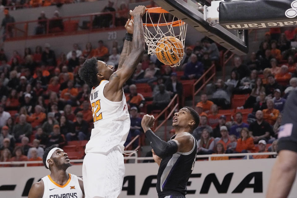 Oklahoma State forward Kalib Boone (22) dunks over Kansas State forward David N'Guessan, right, in the second half of an NCAA college basketball game, Saturday, Feb. 25, 2023, in Stillwater, Okla. (AP Photo/Sue Ogrocki)