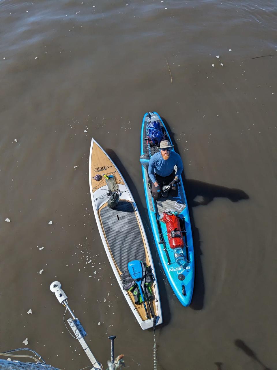 Mason Gravley sits atop his board during a break on Dec. 31 as he and a friend, Jordon Wolfram, crossed Lake Okeechobee on stand-up paddleboards. The pair, both graduates of Southeastern University, have participated for years in endurance ventures by bicycle, kayak, canoe and paddleboard.