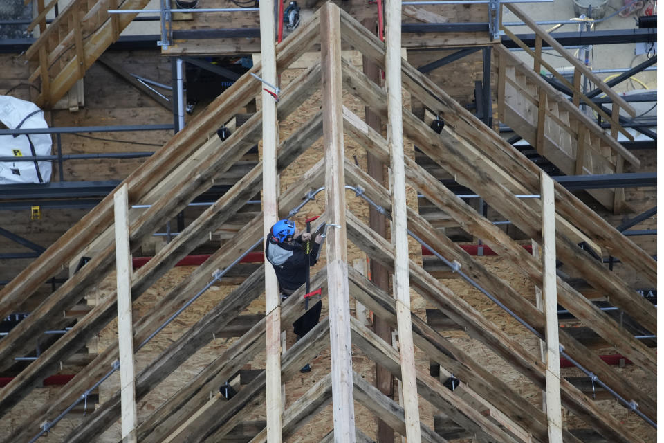 A carpenter works at the roof of Notre Dame de Paris cathedral, Friday, Dec. 8, 2023 in Paris. French President Emmanuel Macron is visiting Notre Dame Cathedral on Friday, marking the one-year countdown to its reopening in 2024 following extensive restoration after the fire four years ago. Macron's visit, continuing his annual tradition since the blaze on April 15 2019, is aimed to highlight the progress in the works, including the near completion of the cathedral spire. (AP Photo/Christophe Ena, Pool)