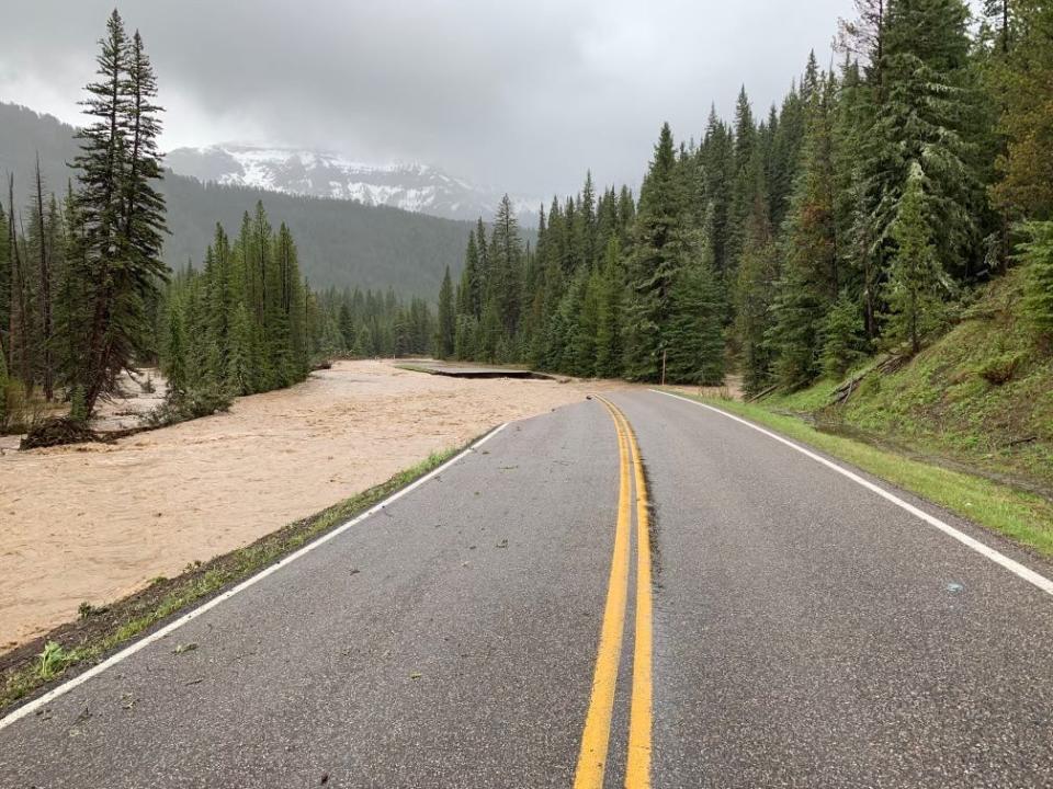 yellowstone road with section washed away in raging river