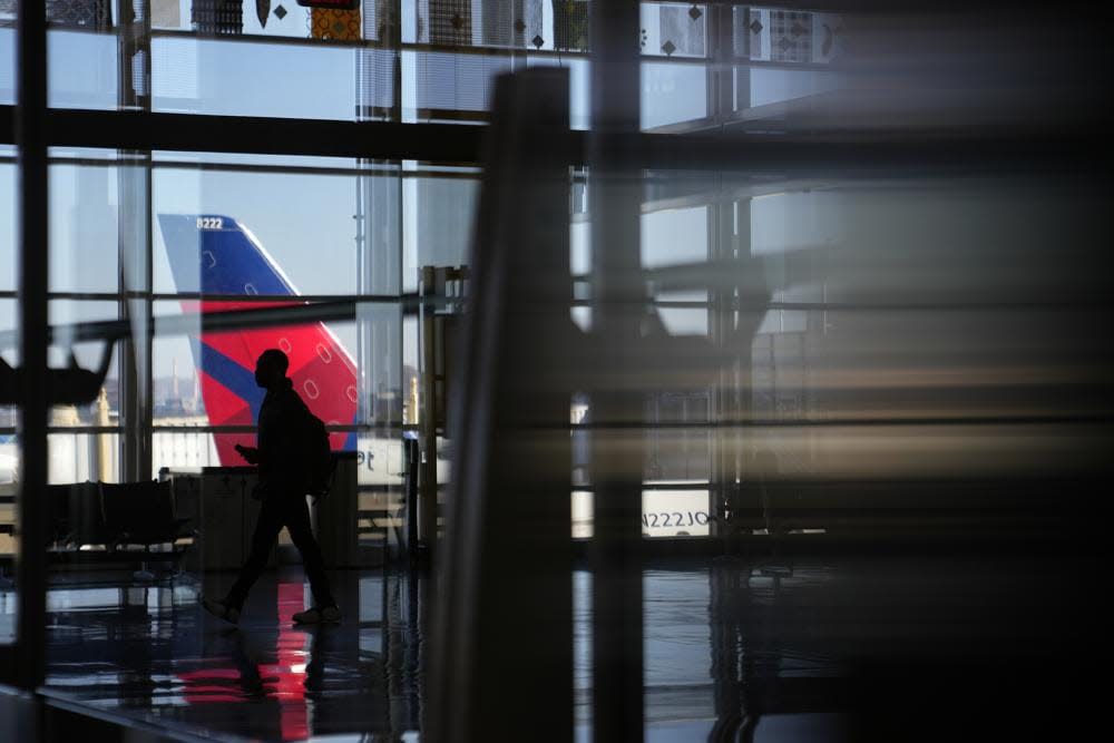 Travelers walk on a concourse at Ronald Reagan Washington National Airport in Arlington, Va., Wednesday, Nov. 23, 2022. (AP Photo/Patrick Semansky)