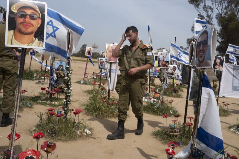 An armed Israeli army officer tours the memorial site in Re'im, southern Israel where Hamas attacked a dance party massacring Israelis who were in attendance. Photo by Jim Hollander/UPI