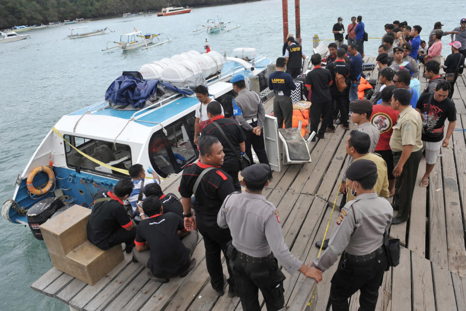 Police and investigators examine a ferry boat following an explosion