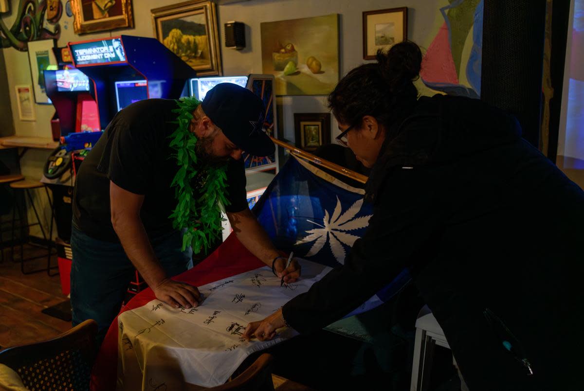 Supporters of the Freedom Act Lubbock sign a flag showing their solidarity with Prop A at a watch party on May 4, 2024.