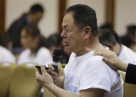 A father whose son was aboard Malaysia Airlines flight MH370, cries as he asks a question during a briefing given by Malaysian representatives at Lido Hotel in Beijing April 21, 2014. REUTERS/Jason Lee