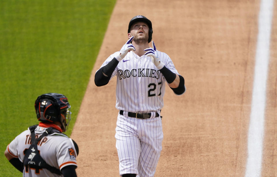 Colorado Rockies' Trevor Story points to the sky after hitting a solo home run as San Francisco Giants catcher Chadwick Tromp looks on during the sixth inning of a baseball game, Thursday, Aug. 6, 2020, in Denver. (AP Photo/Jack Dempsey)