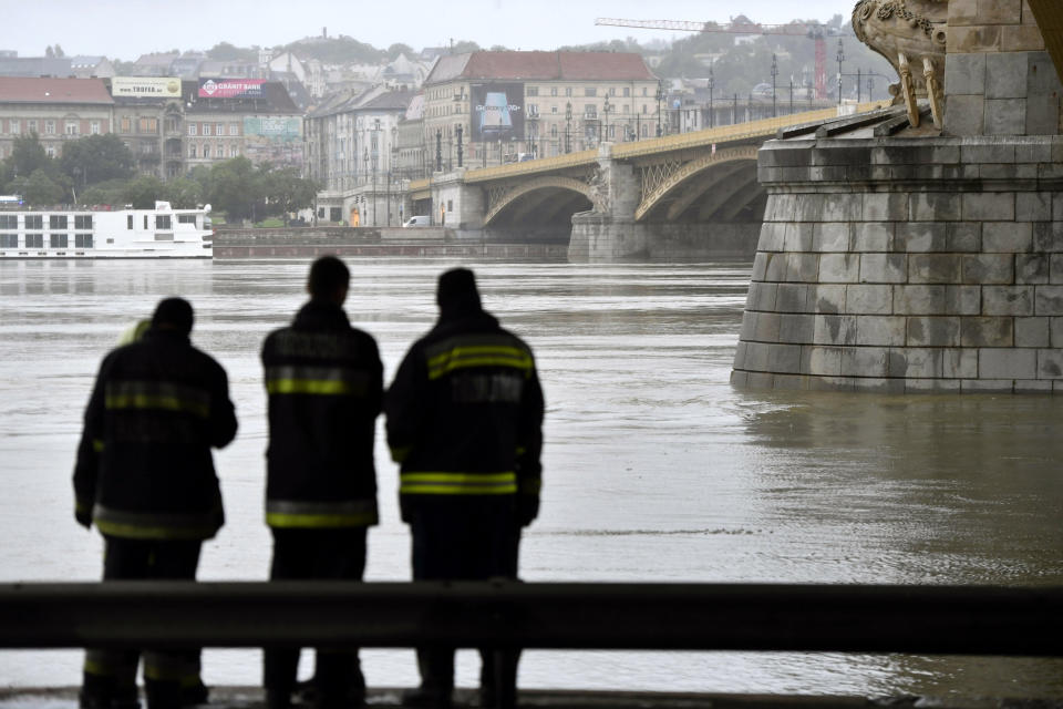 Firemen stand at Margit Bridge, where the wreck of a sightseeing boat was found on the Danube River in downtown Budapest, Hungary, Thursday, May 30, 2019, after a sightseeing boat sank. A massive search was underway on the river for 21 people missing after the sightseeing boat with 33 South Korean tourists sank after colliding with another vessel during an evening downpour. (Zoltan Mathe/MTI via AP)