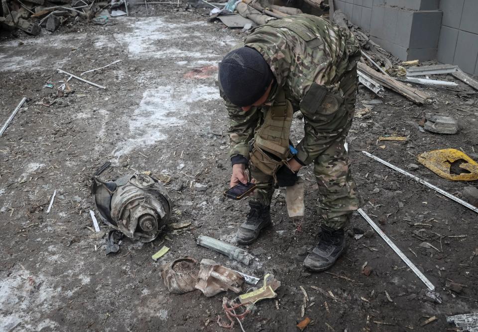 An officer inspects parts of a missile by the site of last night’s strike (Reuters)