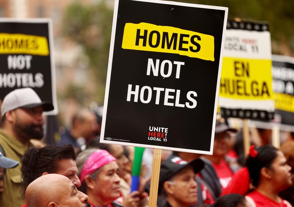 Hotel workers with Unite Here Local 11 prepare to march, as one person holds a 'Homes Not Hotels' sign, through downtown L.A. calling for a fair contract from numerous major hotels in the region on October 25, 2023 in Los Angeles, California.