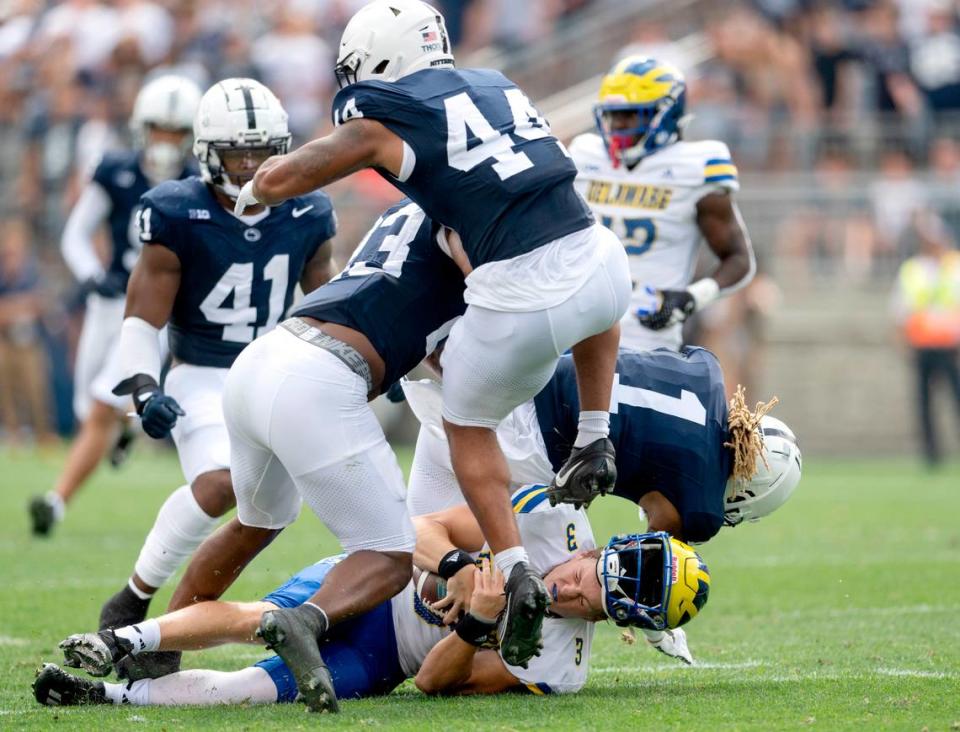 Delaware quarterback Zach Marker’s helmet flies off as he is stopped by Penn State safety Jaylen Reed during the game on Saturday, Sept. 9, 2023.