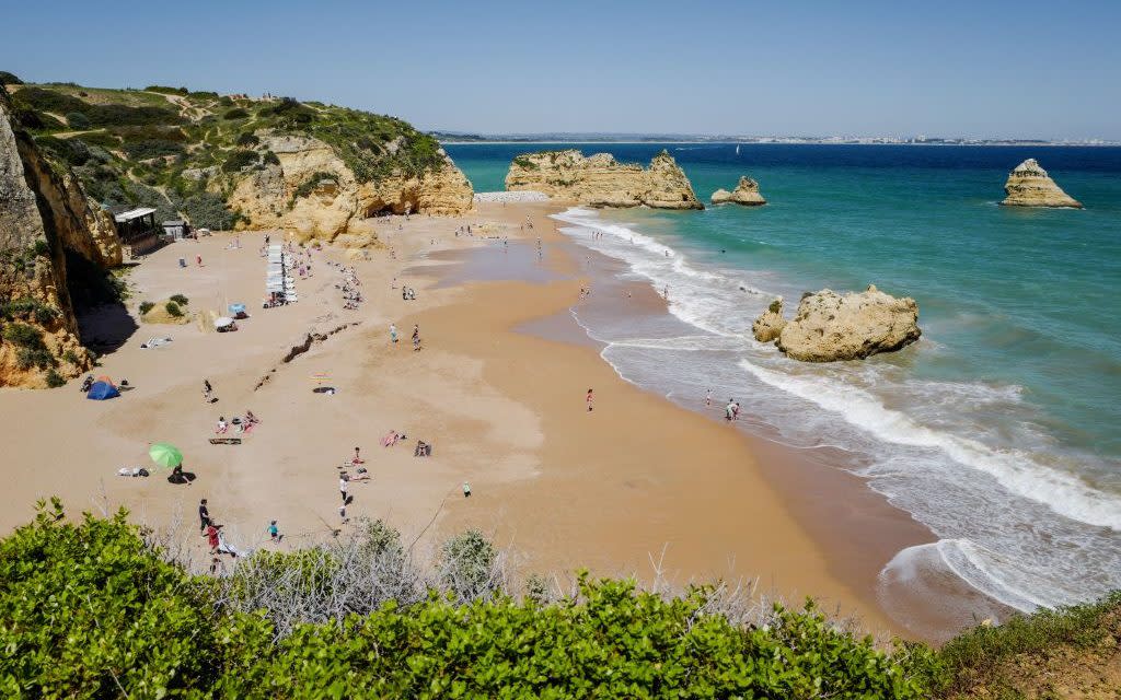 Tourists enjoy the warm weather at the Dona Ana beach in Lagos, Portugal – but maybe not for long - Getty