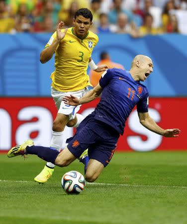 Brazil's Thiago Silva (L) fouls Arjen Robben of the Netherlands to concede a penalty during their 2014 World Cup third-place playoff at the Brasilia national stadium in Brasilia July 12, 2014. REUTERS/Dominic Ebenbichler