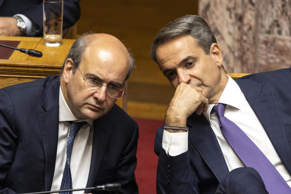 Greece's Prime Minister Kyriakos Mitsotakis, right, speaks with National Economy and Finance Minister Kostis Hatzidakis during a parliament session in Athens, Greece, Saturday, July 8, 2023. The newly elected Greek government won a vote of confidence from the parliament, following a three-day debate. (AP Photo/Yorgos Karahalis)