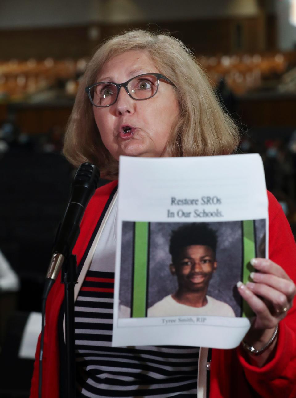 Eileen Serke chastised the JCPS Board of Education for using security during a school board meeting at Central High School in Louisville, Ky. on Oct. 5, 2021. She held an image of Eastern High School student Tyree Smith who was killed recently at a bus stop as she advocated that school resource officers be returned to schools.