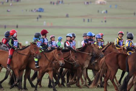 Child jockeys riding horses head to the start line for the Soyolon horse race at the Mongolian traditional Naadam festival, on the outskirts of Ulaanbaatar, Mongolia July 12, 2018. Picture taken July 12, 2018. REUTERS/B. Rentsendorj