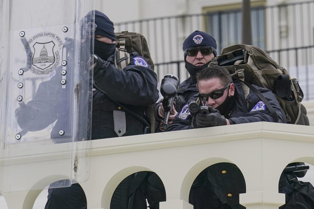 Police keep a watch on demonstrators who tried to break through a police barrier, Wednesday, Jan. 6, 2021, at the Capitol in Washington. As Congress prepares to affirm President-elect Joe Biden's victory, thousands of people have gathered to show their support for President Donald Trump and his claims of election fraud.