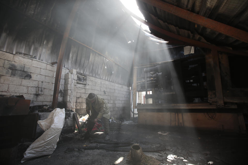 A worker inspects the rubble of a plastic materials factory destroyed by Saudi-led airstrikes, in Sanaa, Yemen, Tuesday, Nov. 23, 2021. (AP Photo/Hani Mohammed)