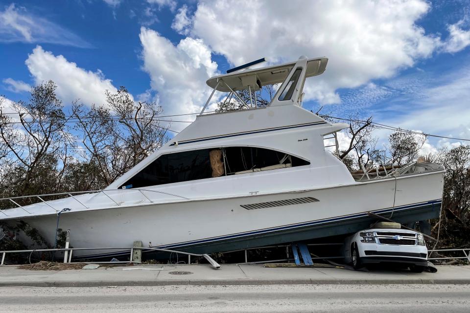 A yacht rests on top of a truck on San Carlos Boulevard in Lee County after Hurricane Ian.